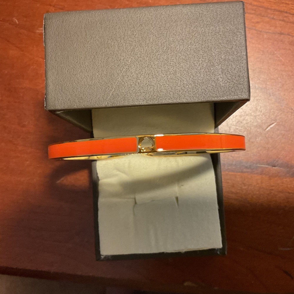Vintage Kate Spade New York Orange Bangle Bracelet with the cut out “Spade”.
